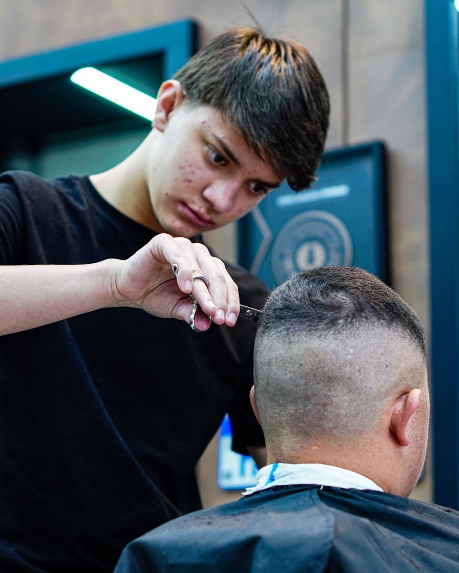 Barbeiro da equipe Hebreus atendendo cliente